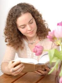 Homestudy student Theresa reading course book by tulips